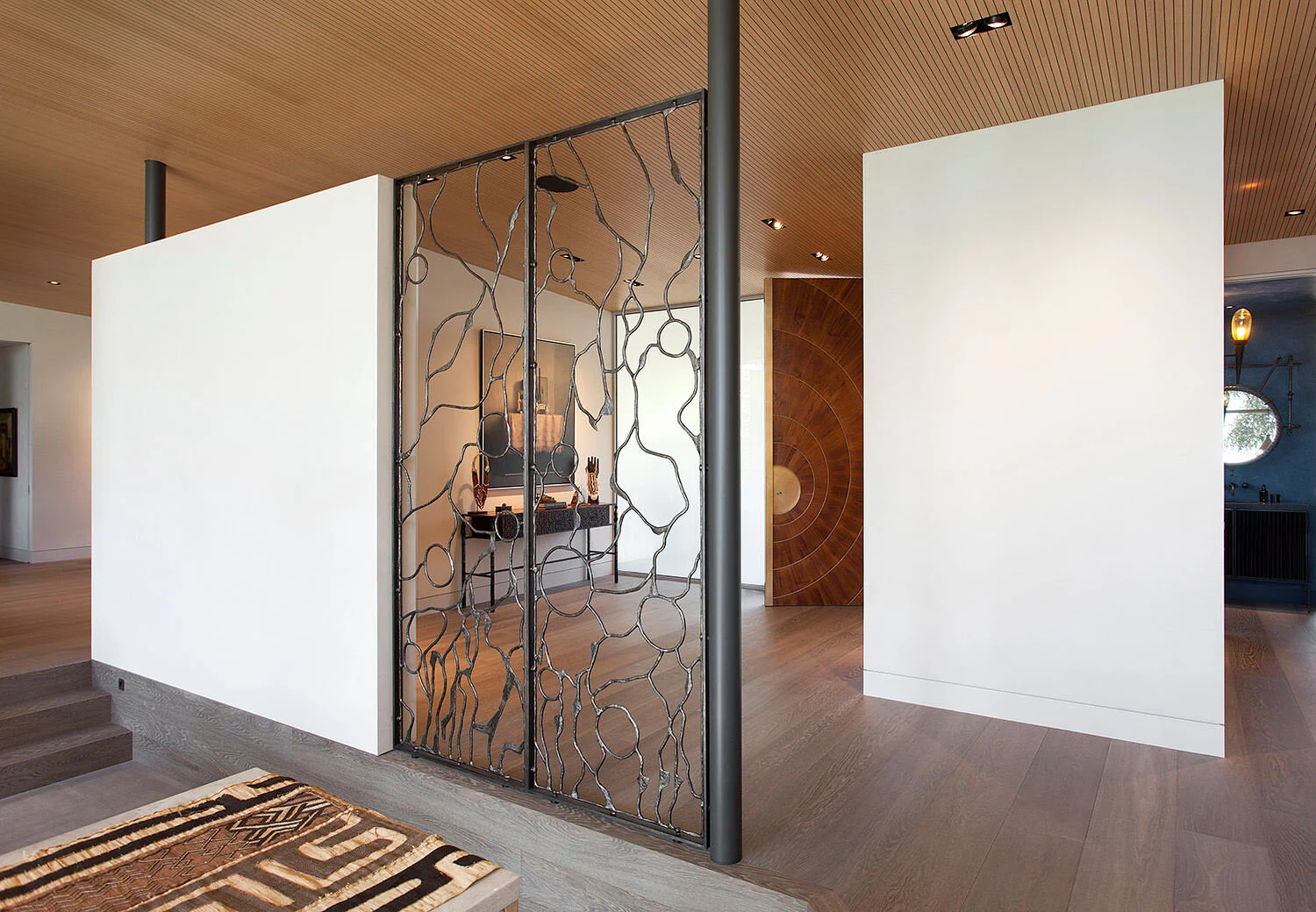  Entry with custom bronze Christophe Côme screen and handmade teak and bronze door at Rocky River, designed by Mark Cravotta. 