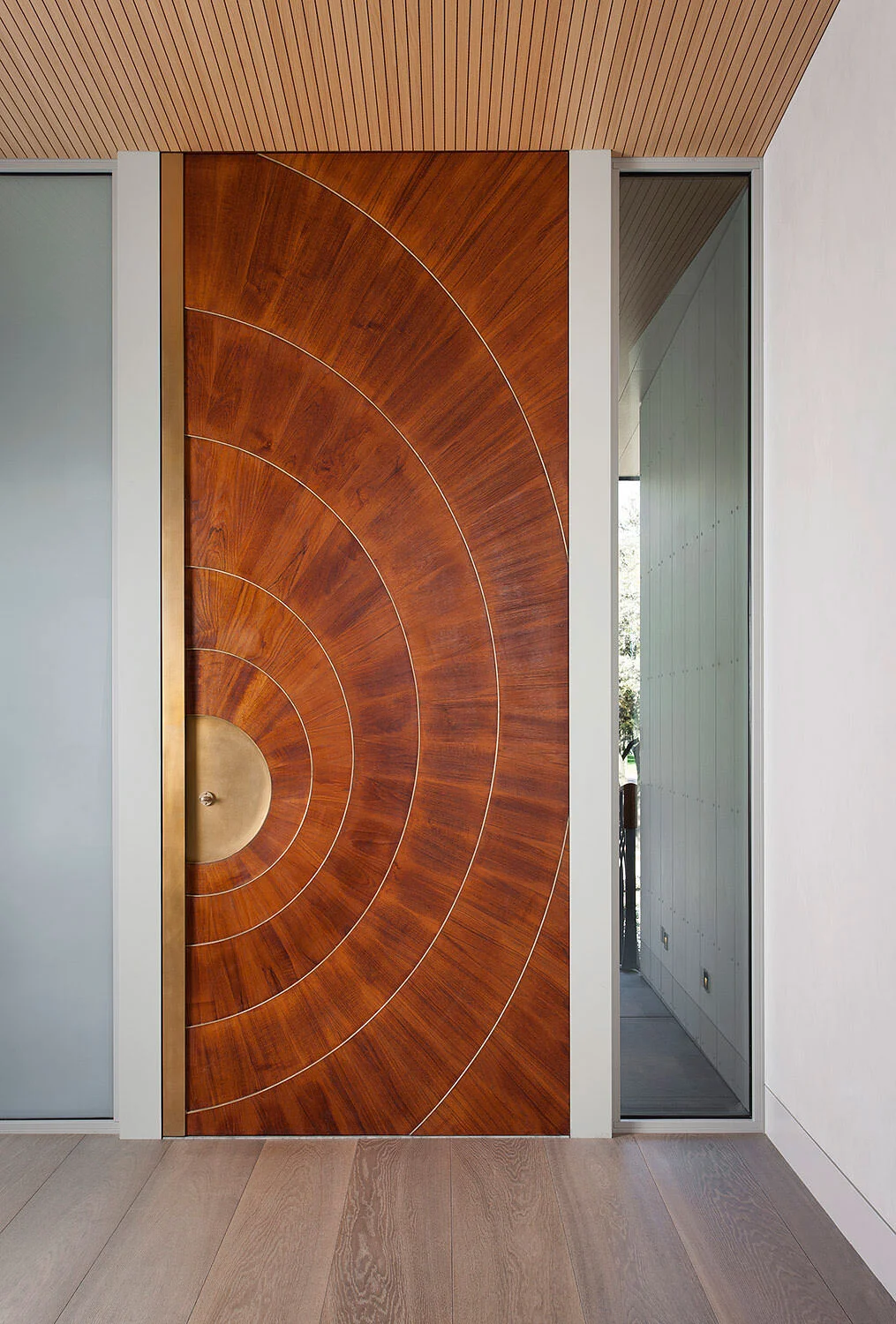  Handmade teak and bronze entry door at the Rocky River Austin residence by Cravotta Interiors. 