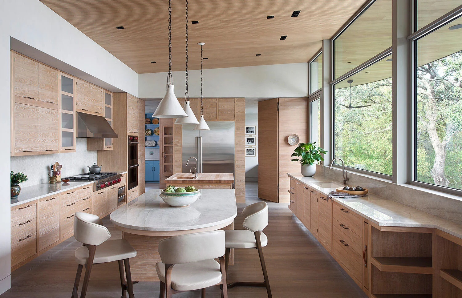  Kitchen with custom Smallbone oak cabinets, handmade ceramic pendant lights, and wood ceiling at Rocky River by Cravotta Interiors. 