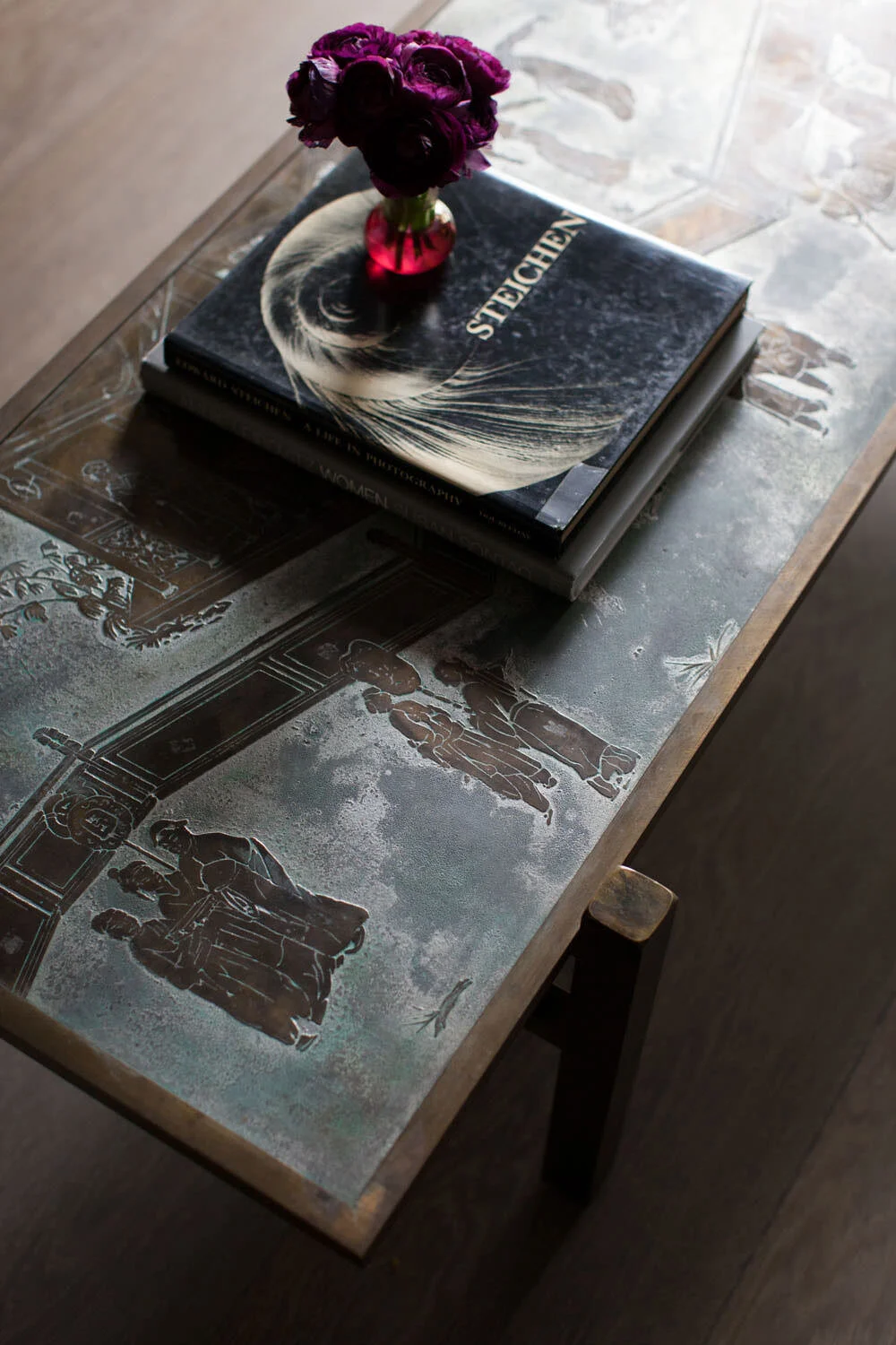  Library coffee table detail with hand-painted silk wallpaper in the background at Rocky River by Cravotta Interiors. 