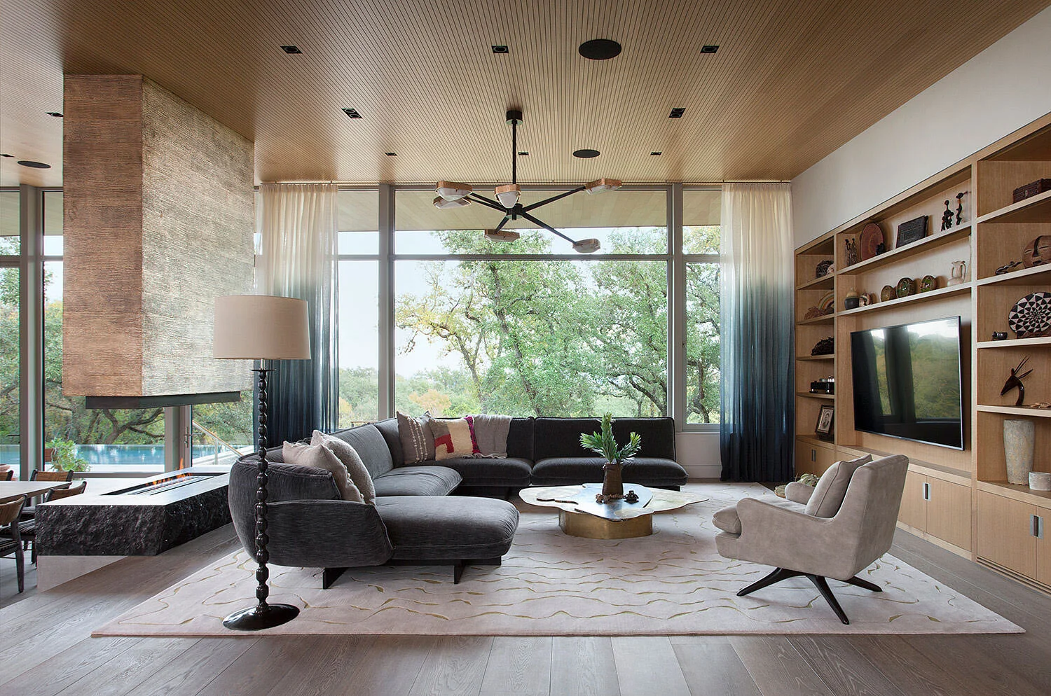  Living room with custom bronze fireplace, Vincenzo De Cotiis coffee table, and Achille Salvagni chandelier at Rocky River, designed by Mark Cravotta. 