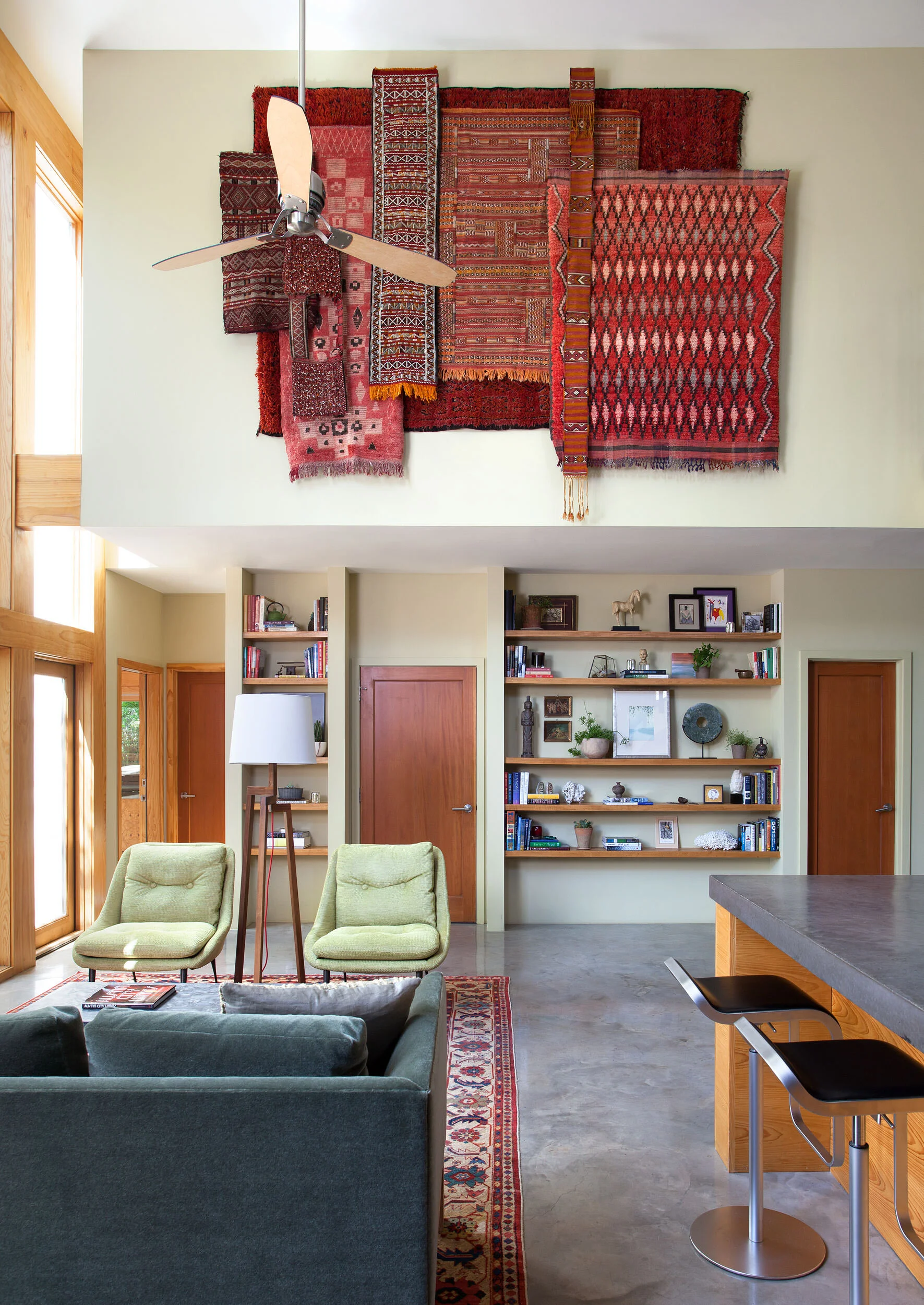  Antique textiles and rugs hung as art in the Zilker Contemporary living room by Cravotta Interiors. 
