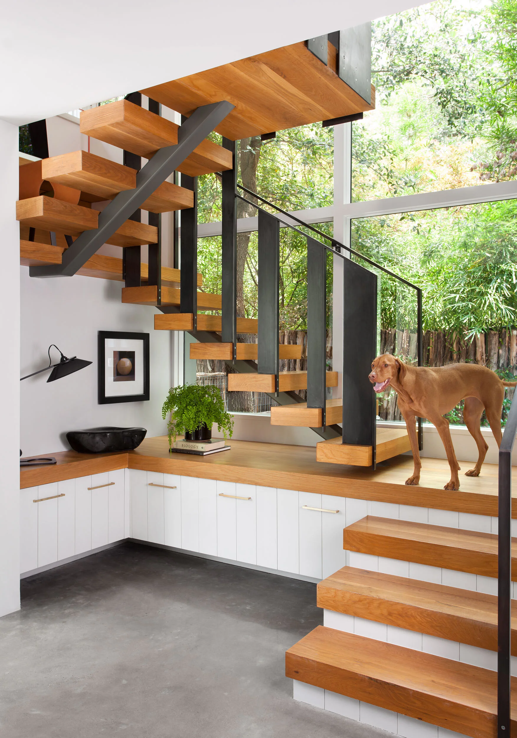  Sculptural staircase with concrete floors in the Clarksville home by Cravotta Interiors. 