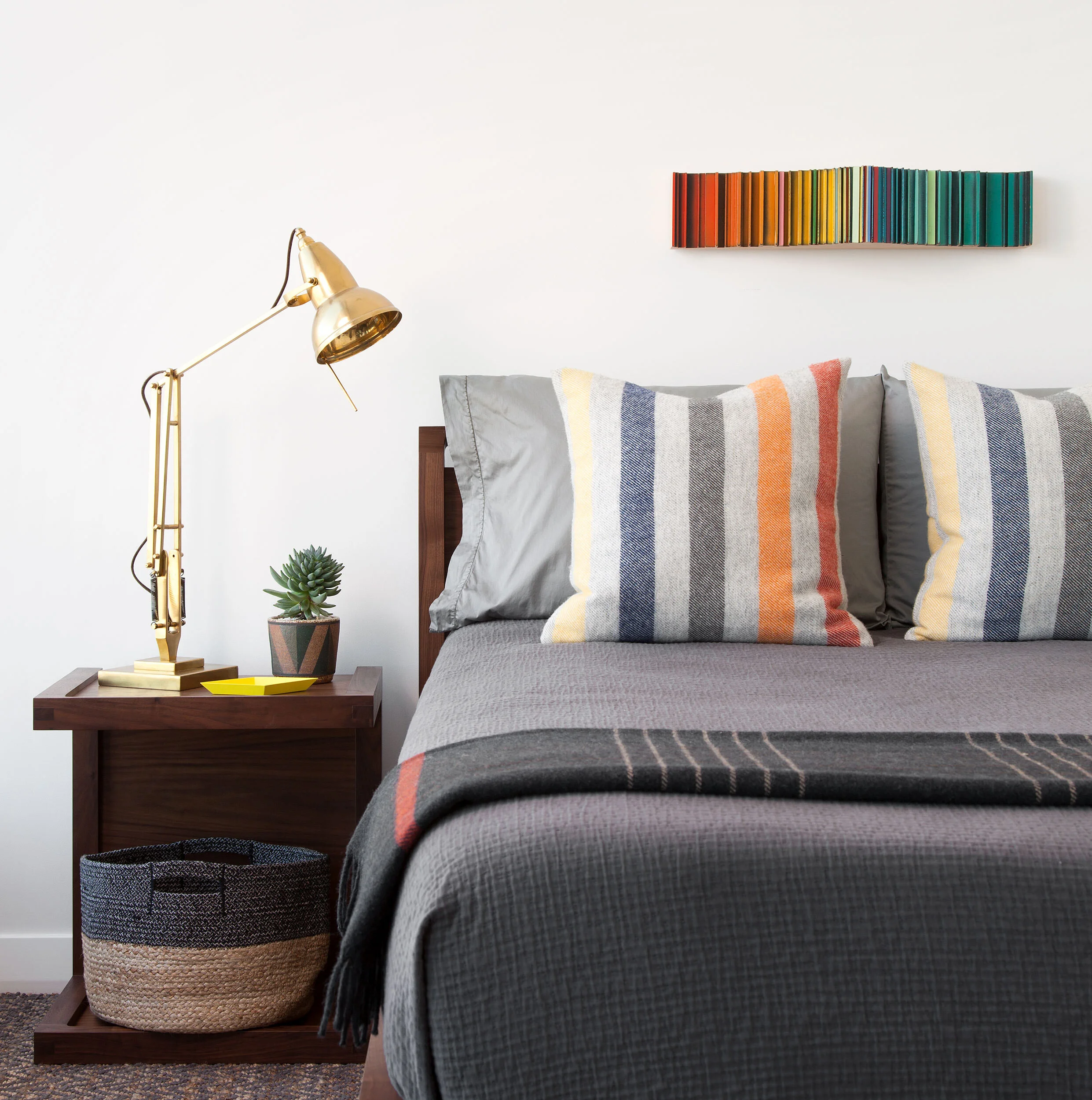  Simple boy's bedroom with walnut nightstand, striped bedding, and Roi James art in the W Penthouse, designed by Mark Cravotta. 