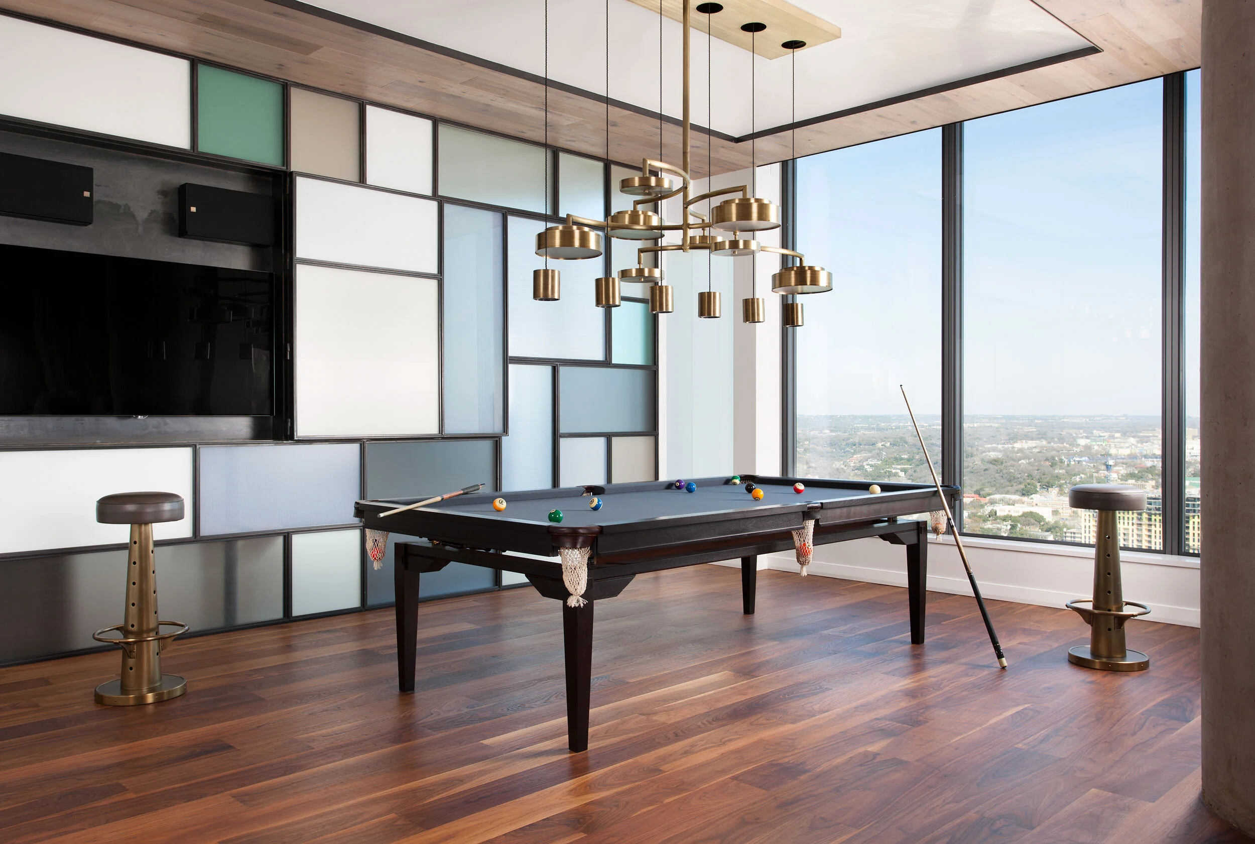  Pool table configuration of the custom convertible dining table with sculptural chandelier above in the W Penthouse by Cravotta Interiors. 