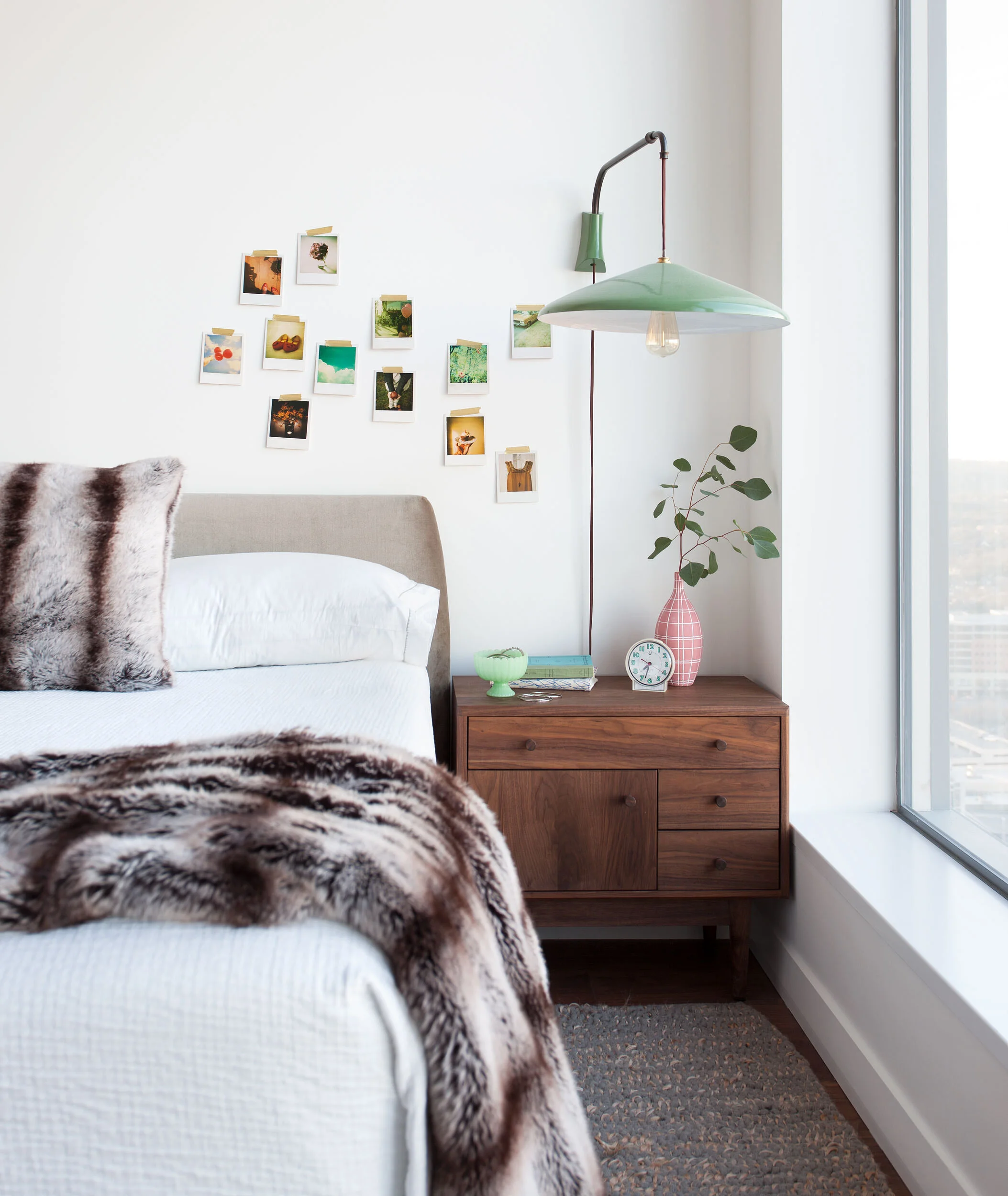  Bright, airy girl's bedroom with walnut nightstand and Polaroid art wall in the W Penthouse by Cravotta Interiors. 