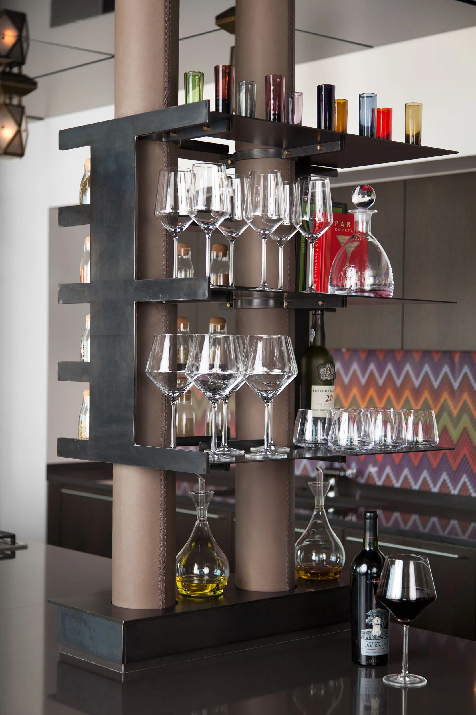  Leather-wrapped pipes and custom steel shelving beneath a gloss ceiling at the W Penthouse bar by Cravotta Interiors. 