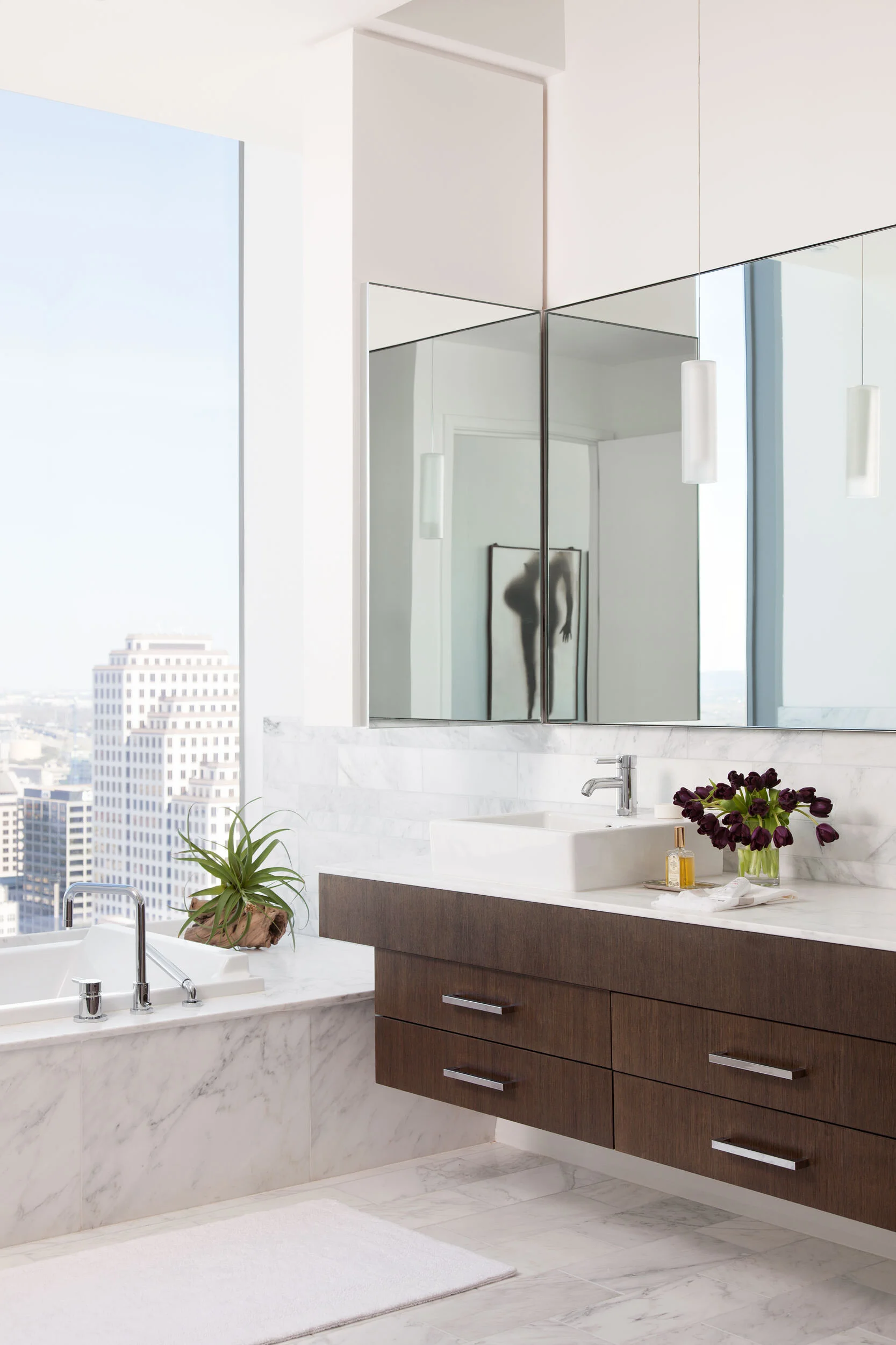  Light-filled primary bathroom with white marble finishes in the W Penthouse by Cravotta Interiors. 