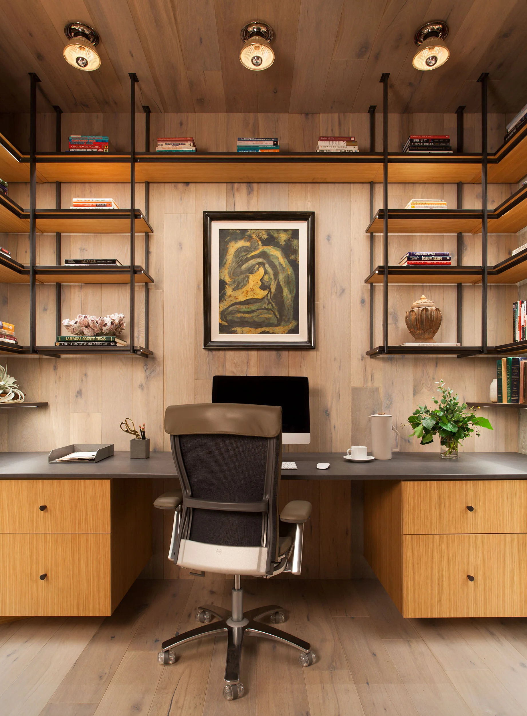  Wood-paneled office with custom steel and wood shelving and leather-wrapped desktop in the W Penthouse by Cravotta Interiors. 