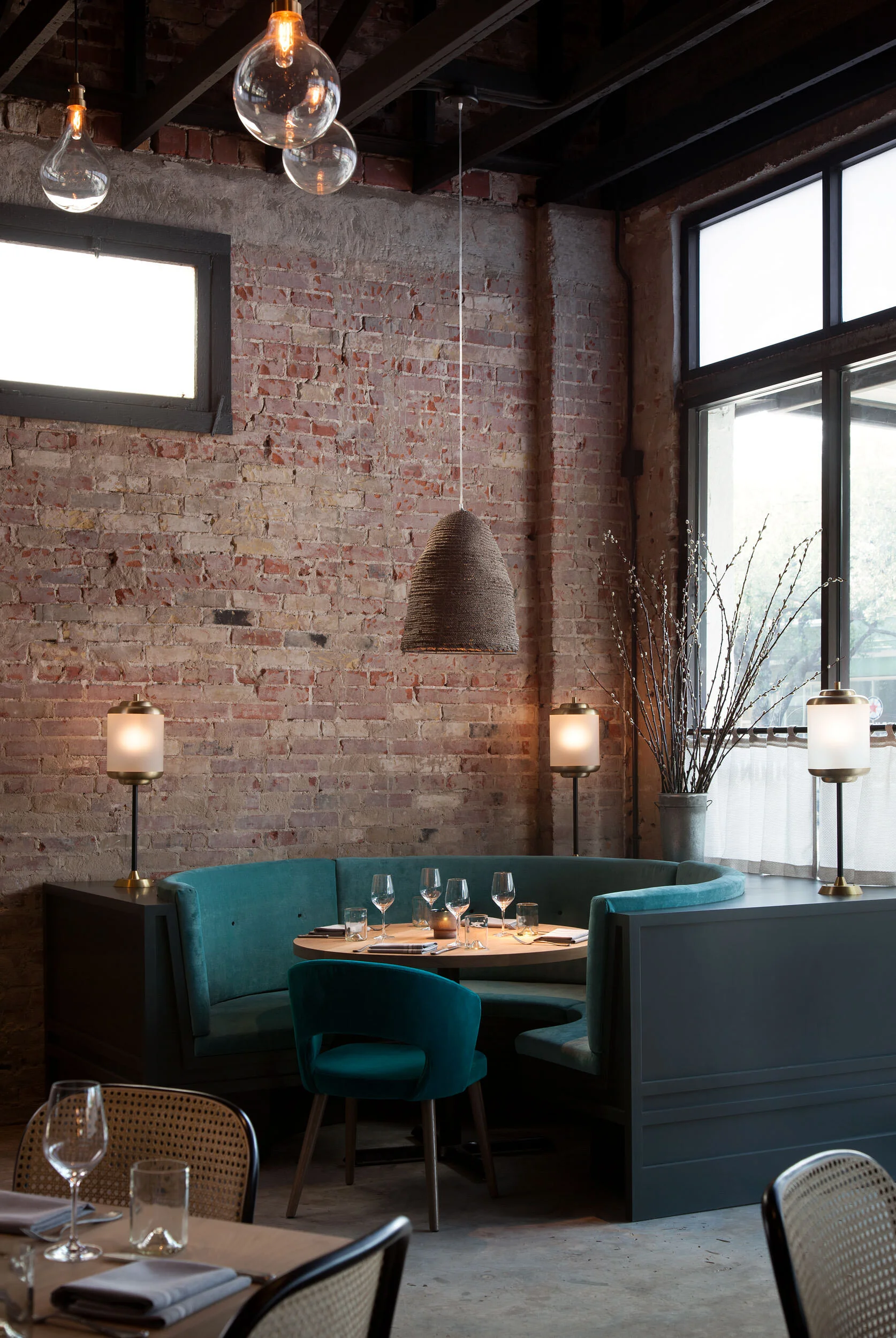  Corner banquette against exposed brick with custom lighting in the Maverick, designed by Mark Cravotta. 