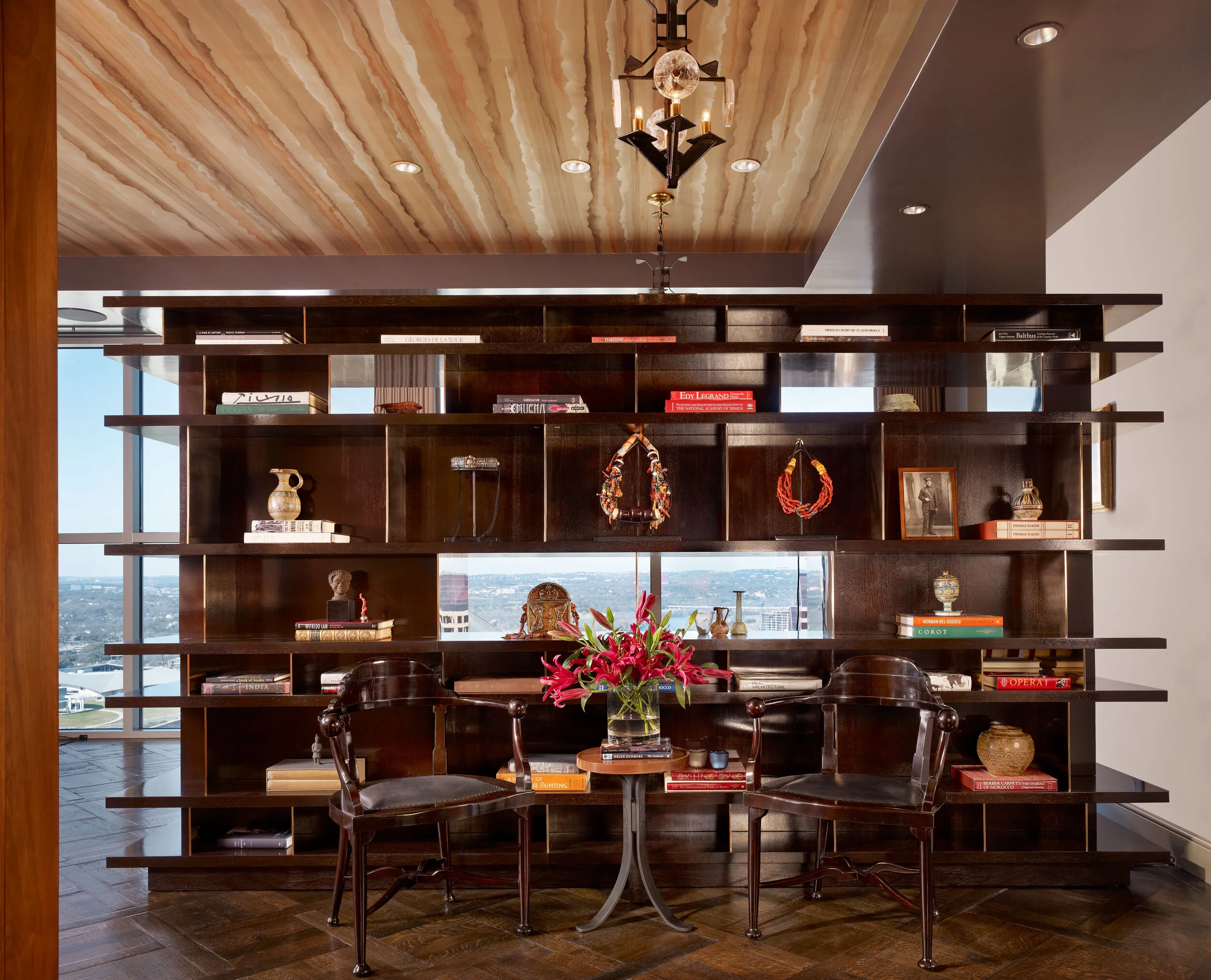  Custom walnut and bronze bookshelf with antique pendant light in the Four Seasons Penthouse by Cravotta Interiors. 
