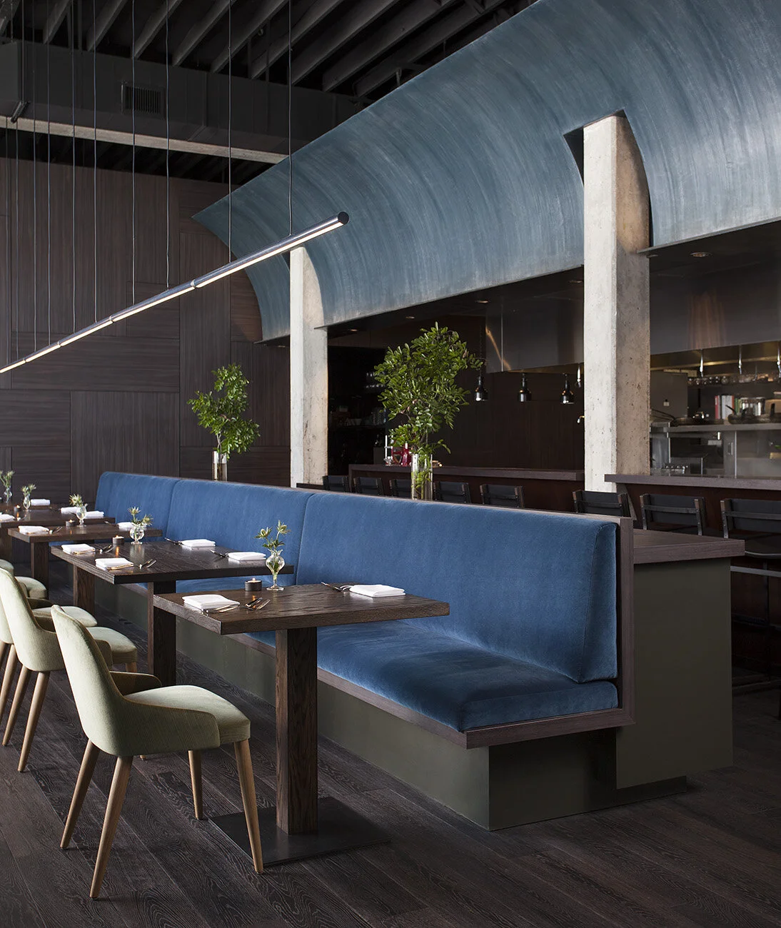 Angled view of the walnut bar beneath the plaster wave with steel windows at Juniper, designed by Mark Cravotta. 