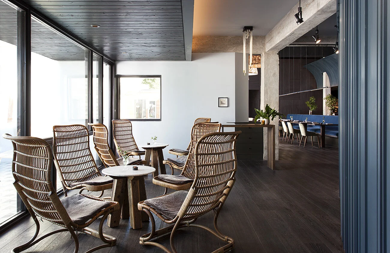  Entry with hand-painted mural, concrete walls, and steel windows at Juniper Restaurant by Cravotta Interiors. 