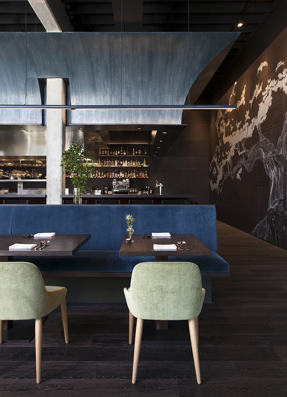  View from banquette seating toward the walnut bar and hand-painted mural at Juniper, designed by Mark Cravotta. 