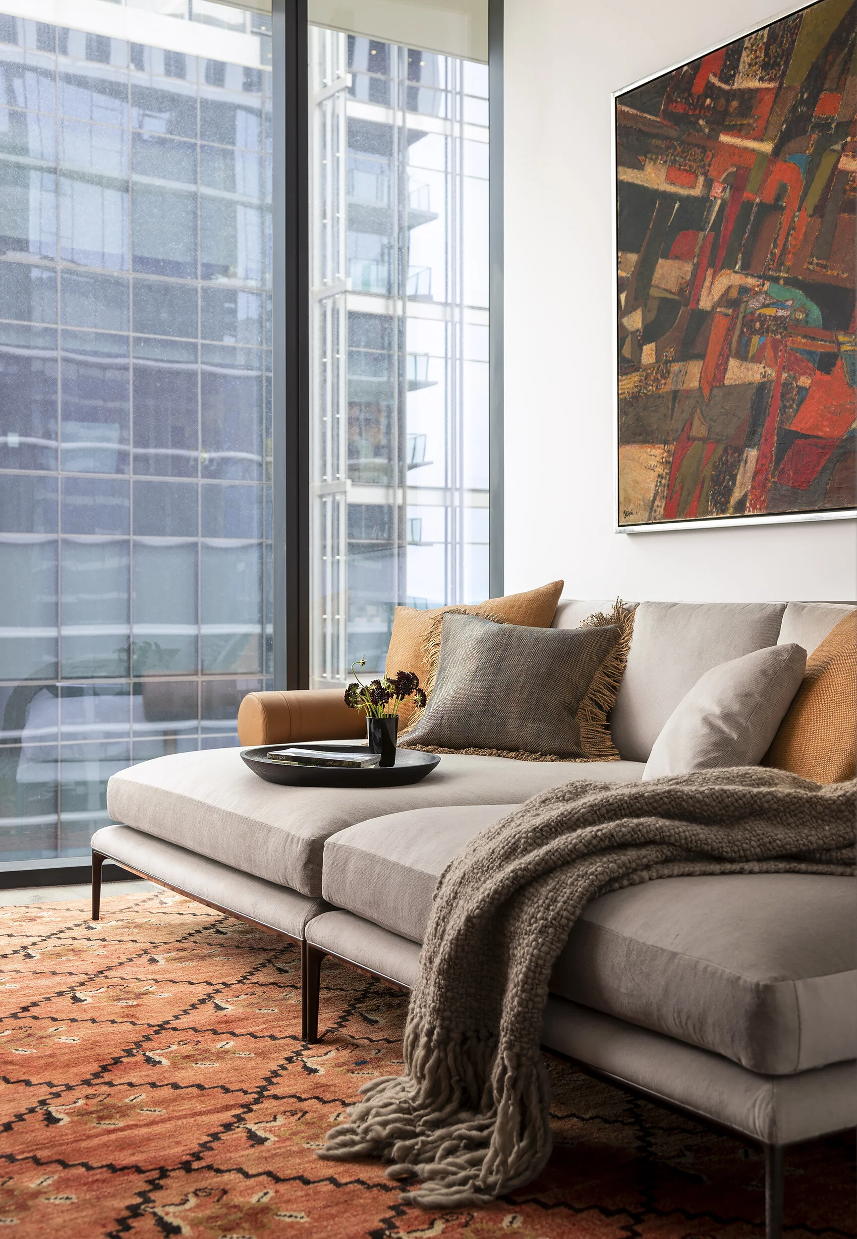  TV room with vintage rug, deep seating, and mid-century art in the Proper Penthouse by Cravotta Interiors. 