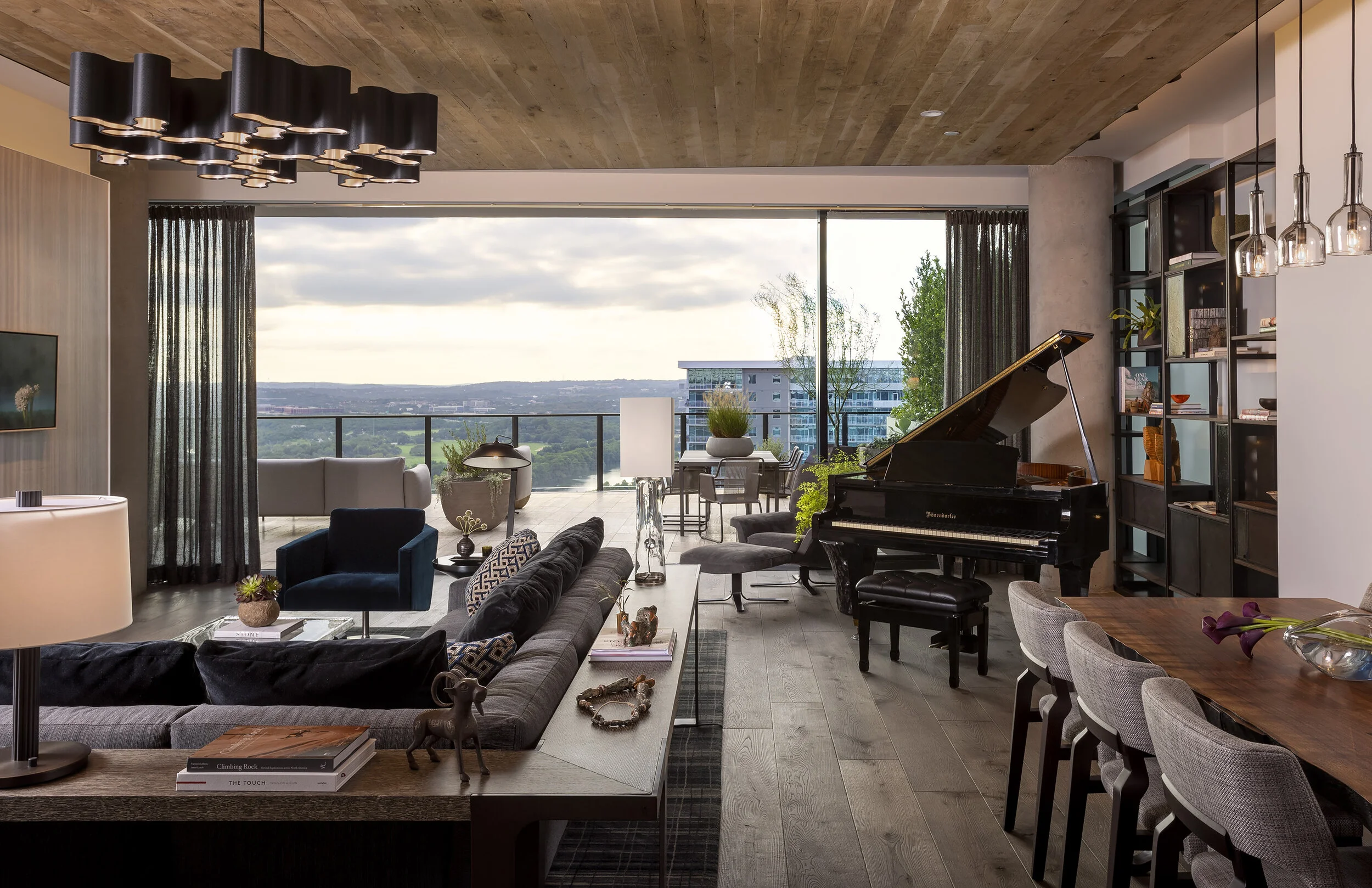  Living room opening to the terrace with wood ceiling, custom shelving, and piano at the Austin Proper Penthouse, designed by Mark Cravotta. 