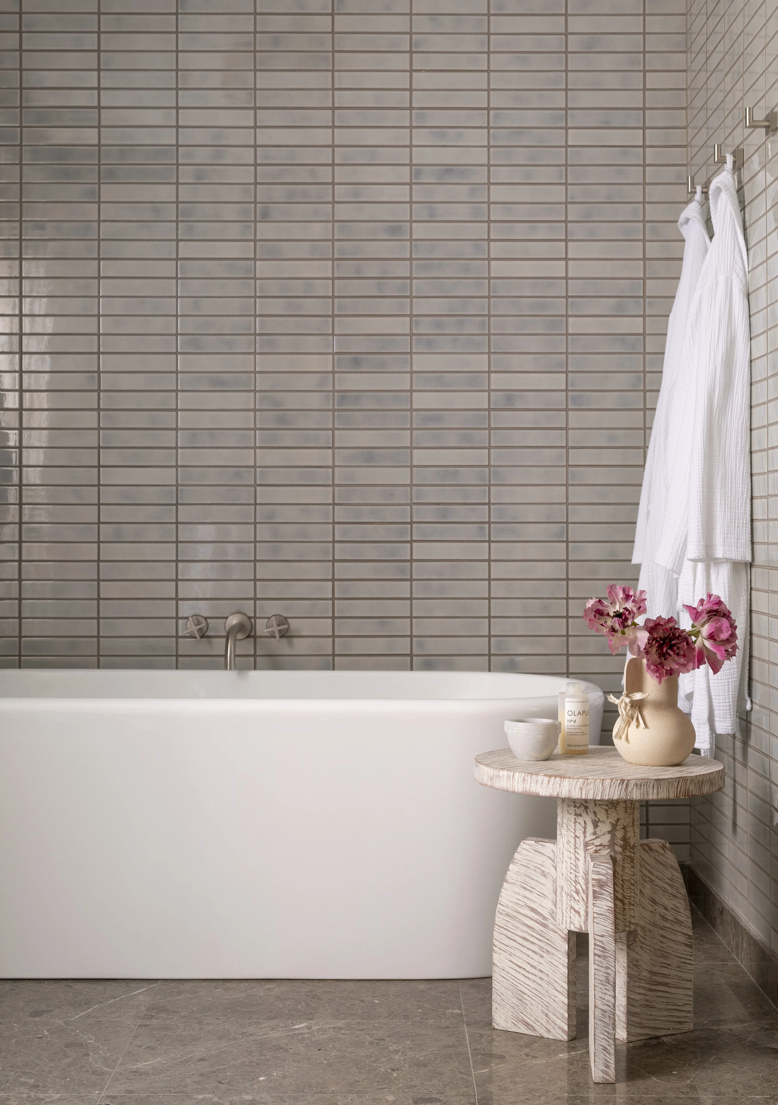  Primary bath with gray stone floors and handmade tile walls at the Proper Residence, designed by Mark Cravotta. 