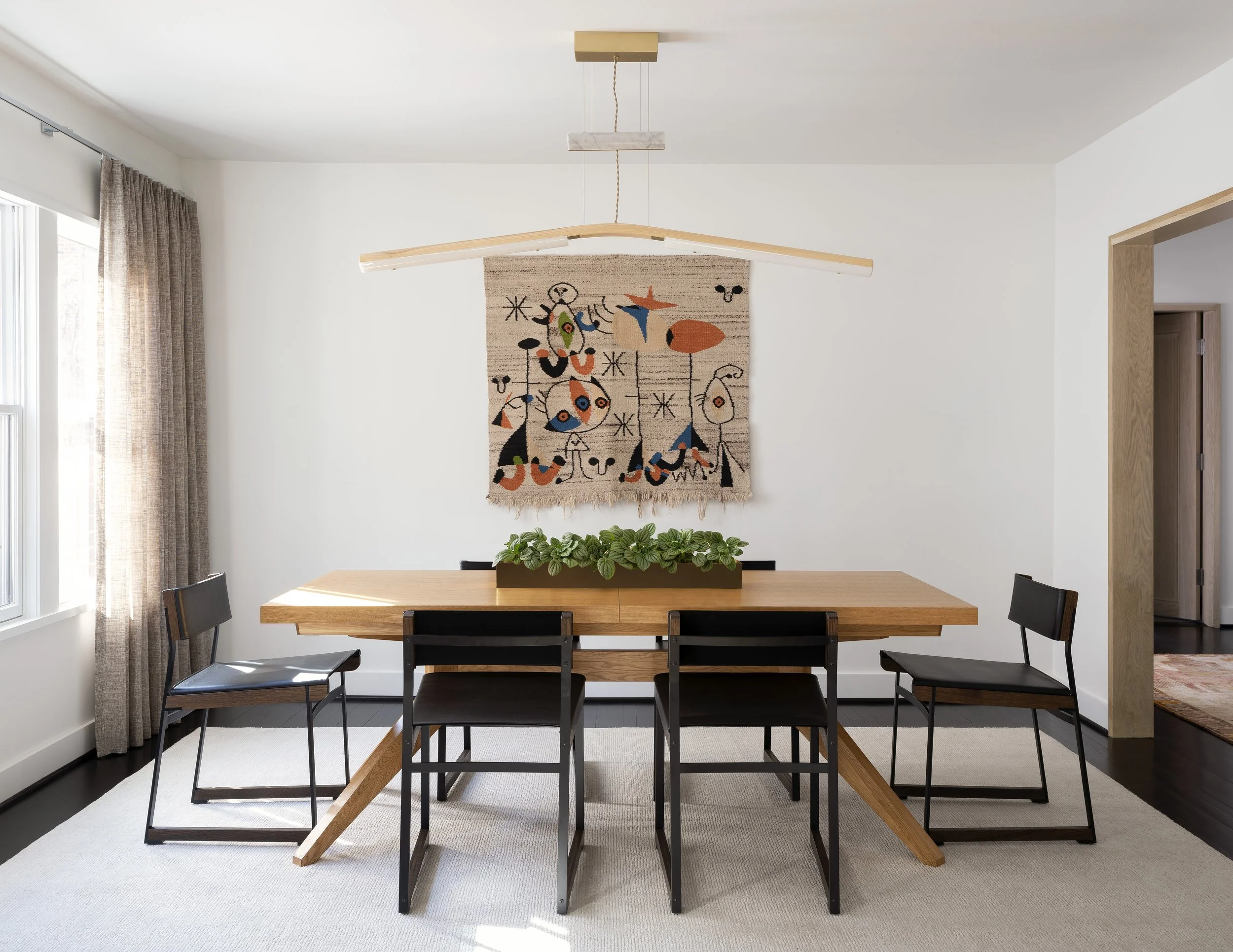  Dining room with vintage Miró tapestry, sheer drapes, and leather and steel chairs at Boulevard Oaks, designed by Mark Cravotta. 