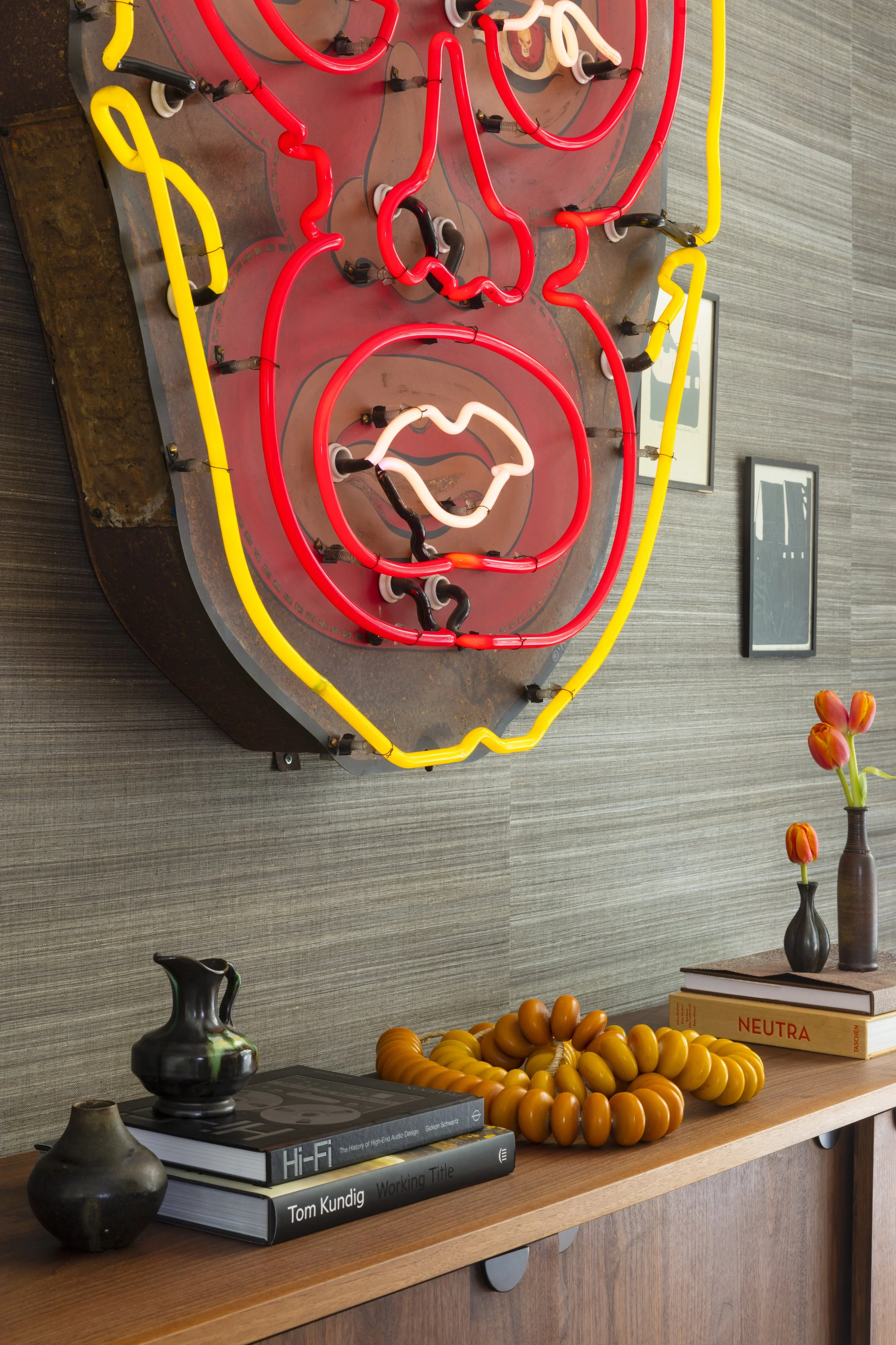  Custom neon sign above dark grasscloth wallpaper in the Rabb Road dining room, designed by Mark Cravotta. 