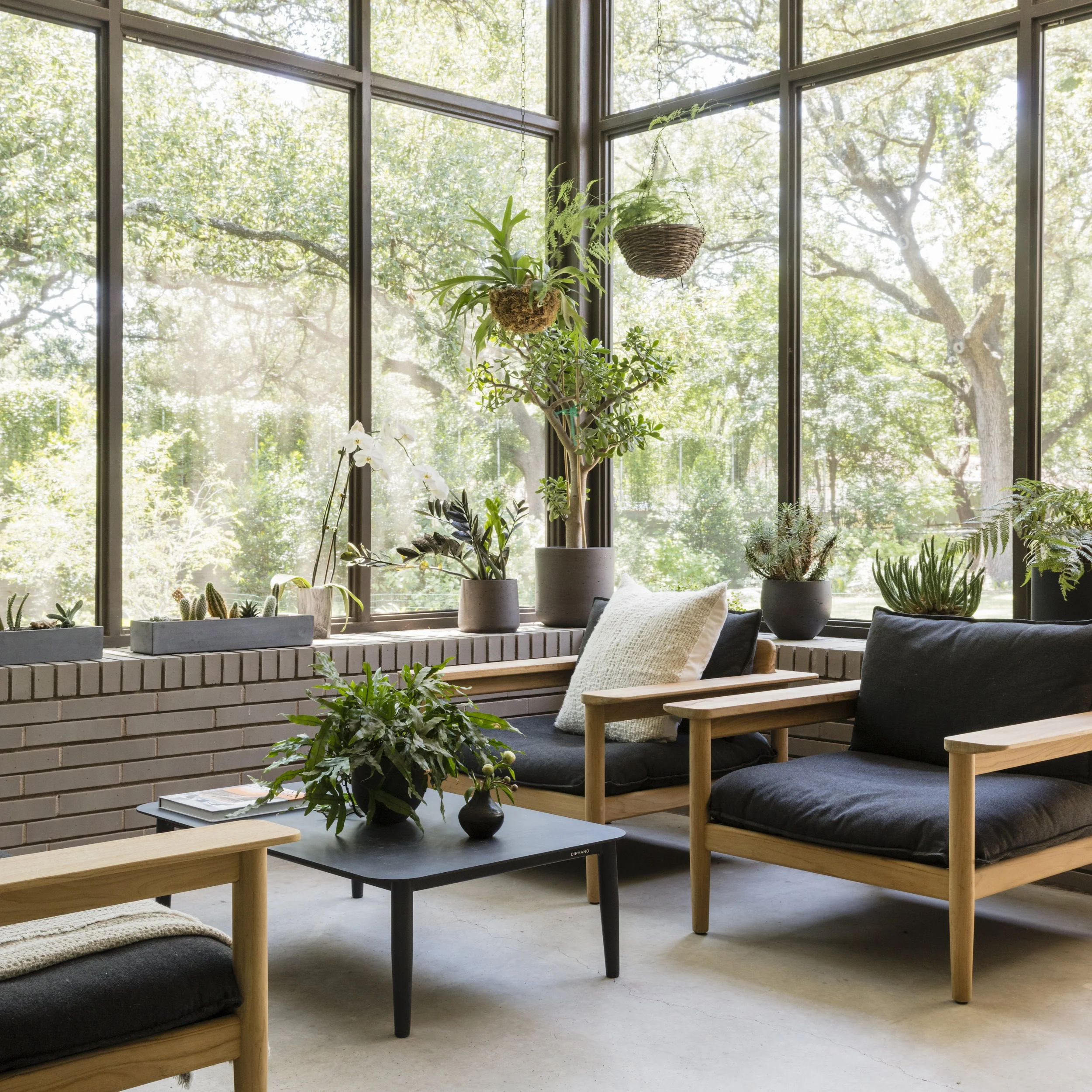  Screened porch with brick wall and lush plants at the Rabb Road South Austin home by Cravotta Interiors. 