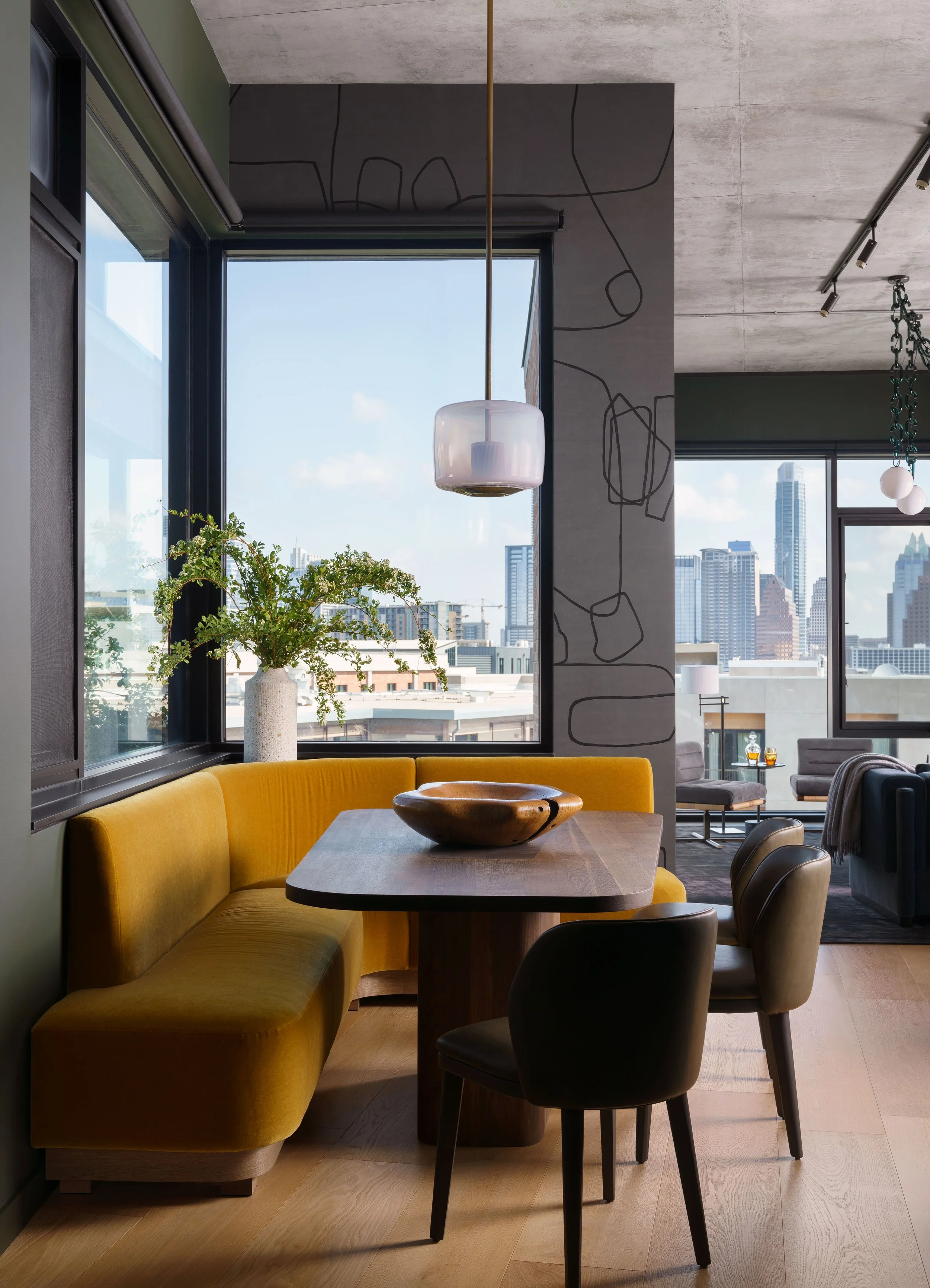  Breakfast nook with custom dining table, built-in banquette, hand-painted wallpaper, and JMW Studio light at St. Cecilia, designed by Mark Cravotta. 