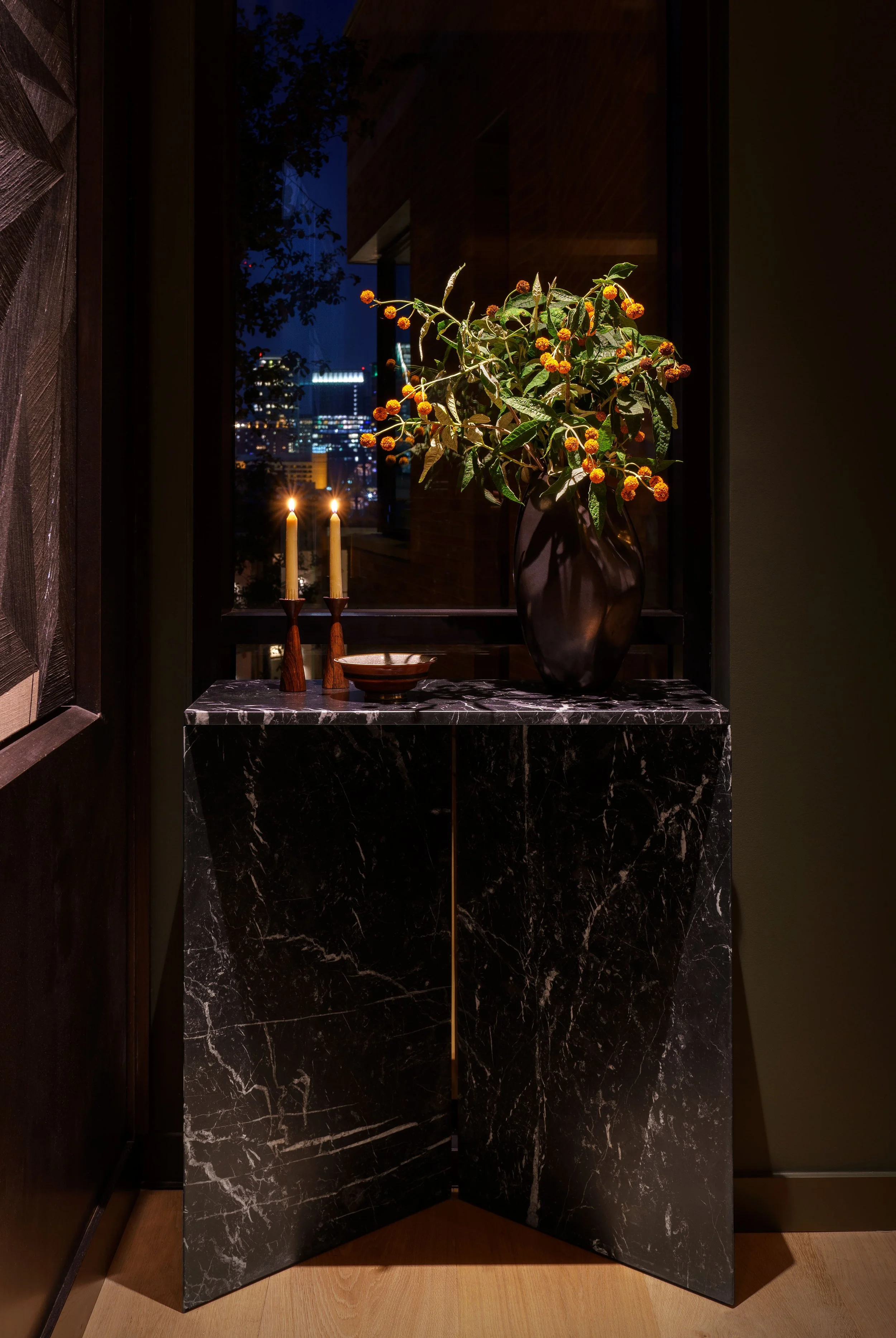  Marble console table set against dark wood paneling in the St. Cecilia condo foyer by Cravotta Interiors. 