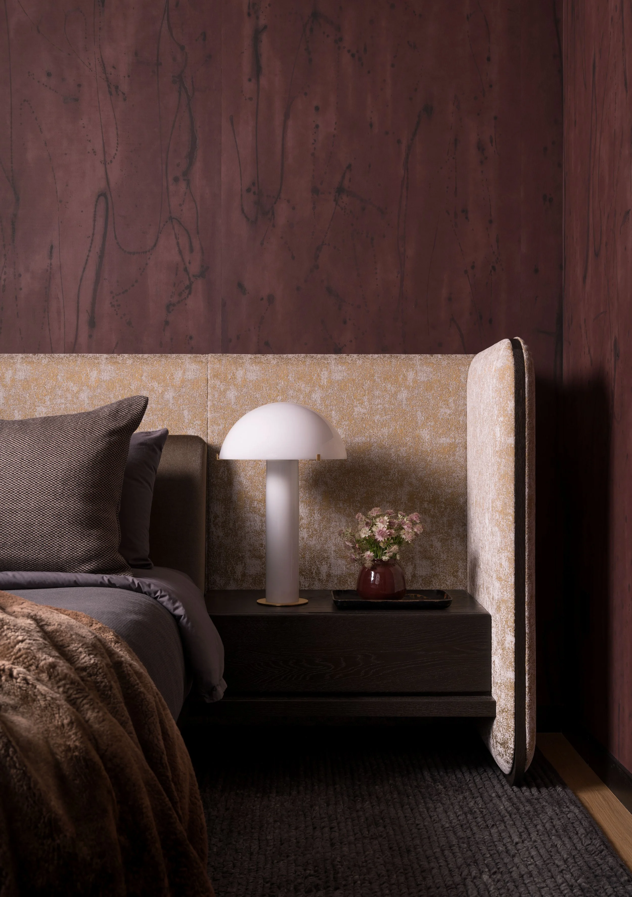  Bedside detail showing Porter Teleo wallpaper texture and Jiun Ho headboard in the St. Cecilia primary bedroom, designed by Mark Cravotta. 